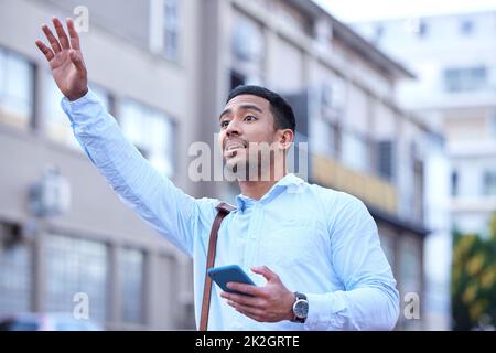 Ho bisogno di te per portarmi in centro. Shot di un giovane uomo d'affari che si accaparta un taxi. Foto Stock