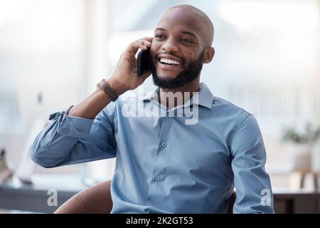 Im contento che tu abbia chiamato. Scatto corto di un bel giovane uomo d'affari che fa una chiamata mentre si siede nel suo ufficio. Foto Stock