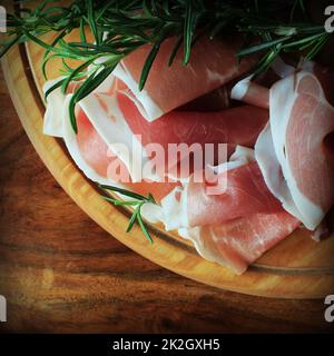 Fette di prosciutto su un tagliere Foto Stock