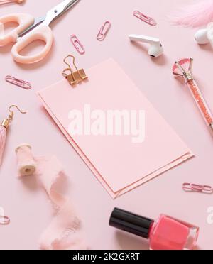 Carta con clip e accessori rosa scuola girly su rosa pastello primo piano, mockup Foto Stock