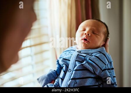 Non riesco a smettere di guardarlo, anche quando dorme. Scatto di un ragazzino stanco che dorme con gli occhi chiusi mentre sua madre lo tiene in mano a casa. Foto Stock