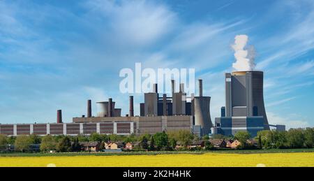 Centrale elettrica a carbone di fronte a un campo di colza a Niederaussem, nei pressi di Colonia Foto Stock