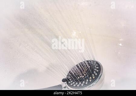Gocce d'acqua cadono dalla lattina d'acqua nel primo piano della doccia. Il flusso di acqua. Nella doccia è possibile innaffiare un'abbondante lattina rotonda Foto Stock