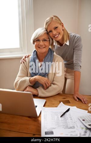 Prestito di una mano con le dichiarazioni di imposta di Grandmas. Una nipote che aiuta la nonna con il suo budget. Foto Stock