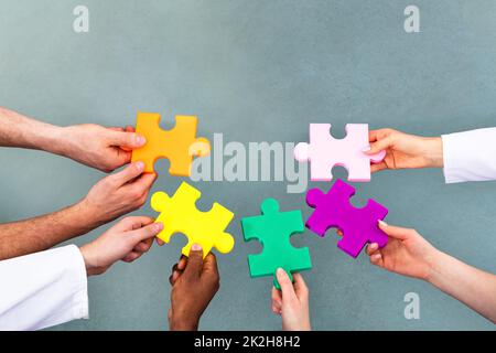 Angolo di Alta Vista del Team Medico risolvere puzzle Foto Stock