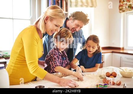 Le gioie della cottura. Shot ritagliato di una famiglia che cuoce insieme a casa. Foto Stock