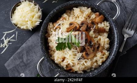 Risotto ai funghi guarnito con prezzemolo e parmigiano. Foto Stock