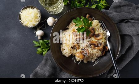 Risotto ai funghi guarnito con prezzemolo e parmigiano. Foto Stock