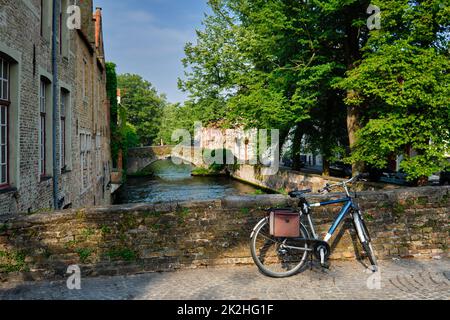 Bicyccle su un ponte vicino al canale e vecchie case. Bruges Brugge , Belgio Foto Stock
