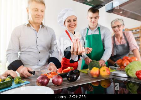 Dietista che mostra ai suoi apprendisti come cucinare in modo sano Foto Stock