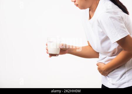 La donna usa la mano che tiene il latte di vetro lei è stomaco difettoso dolore Foto Stock