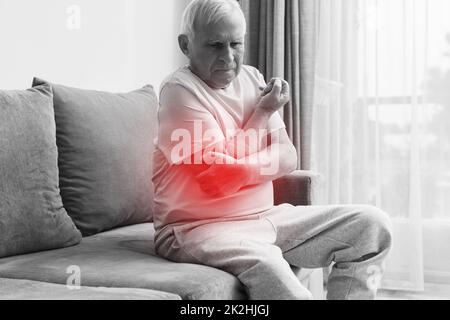 Uomo anziano che soffre di dolore al gomito Foto Stock