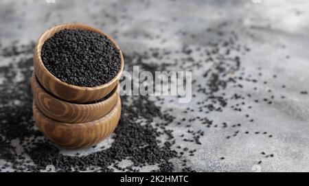 Spezie indiane semi di cumino nero (nigella sativa o kalonji) in ciotole di legno primo piano Foto Stock