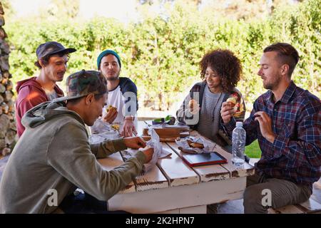 Ritrovo con gli amici. Un gruppo di amici intorno ad un tavolo all'aperto. Foto Stock
