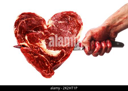 Mano maschio con coltello sanguinoso pugnalata nella carne a forma di cuore Foto Stock