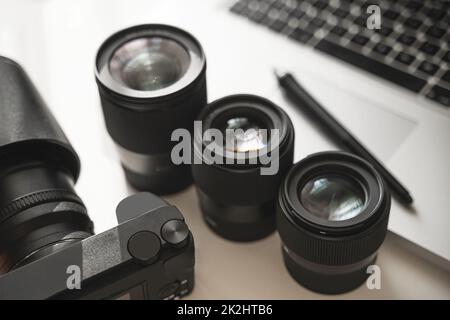 Ambiente di lavoro con attrezzature moderne per la fotografia. Fotocamera Mirrorless e obiettivi a focale fissa. Foto Stock