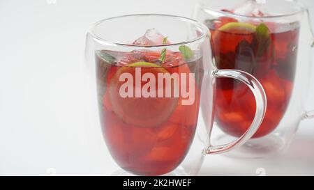 Bevanda a base di tè freddo Hibiscus con cubetti di ghiaccio e limone in bicchiere Foto Stock