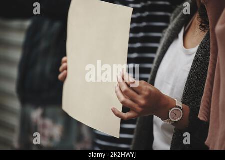 Facendo conoscere la sua opinione. Scatto corto di una donna irriconoscibile che tiene un segno mentre prende parte ad un rally politico. Foto Stock