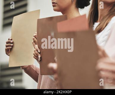 Non alzarsi. Un'immagine ritagliata di un gruppo di persone irriconoscibili che hanno dei segni mentre prendono parte a un raduno politico. Foto Stock