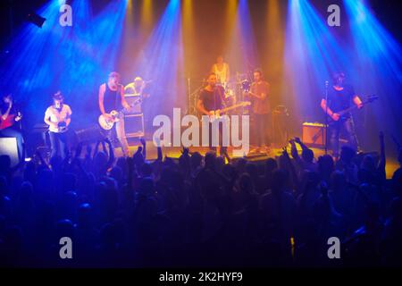 Questa banda è sempre disponibile. Ripresa di una grande folla in un concerto musicale - questo concerto è stato creato per l'unico scopo di questo servizio fotografico, con 300 modelli e 3 band dal vivo. Tutte le persone in questo sparo sono modello rilasciato. Foto Stock