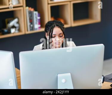 Il duro lavoro assicurerà il suo successo. Scatto ad alta angolazione di una giovane donna attraente che lavora su un computer nel suo ufficio domestico. Foto Stock