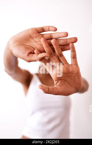 È problemi di pelle che ti fanno voler nascondere. Studio girato di una donna irriconoscibile nascondendosi dietro le sue mani. Foto Stock