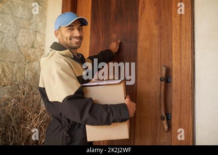 Consegna puntualmente del pacchetto. Ritratto di un uomo sorridente che tiene un pacco e bussa alla porta di un cliente. Foto Stock