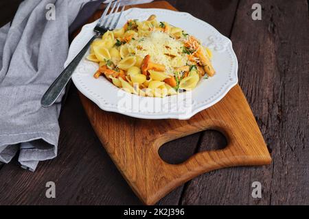 Pasta con crostini biologici. Porzione di pasta con crostini fritti in salsa cremosa all'aglio con formaggio a vista su un piatto a tavola Foto Stock