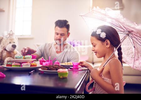 Ogni grande ricordo d'infanzia include una festa reale del tè. Fucilato di un padre e di sua figlia che hanno una festa del tè insieme a casa. Foto Stock