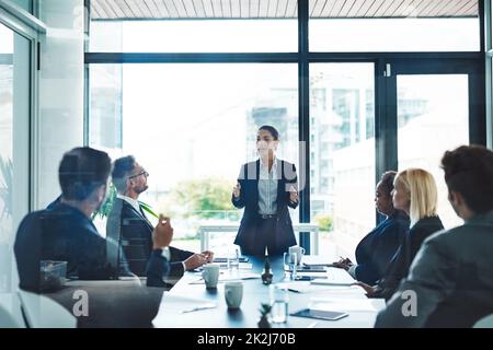 Scendendo alle prese di ottone. Scatto corto di una giovane donna d'affari attraente che dà una presentazione nella sala del consiglio. Foto Stock