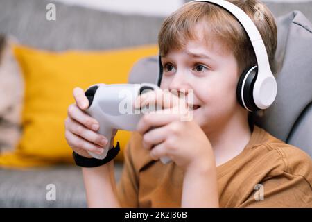 Ritratto di ragazzo concentrato teen con un joystick nelle sue mani giocando la console. Foto Stock