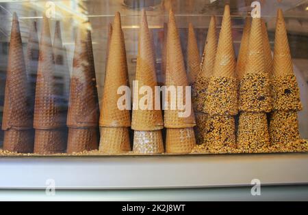 Un mucchio di cialda coni per gelato pronto per essere riempito con gelato in un bar e il ristorante. Vetrina di un bar, una pasticceria e un ristorante Foto Stock