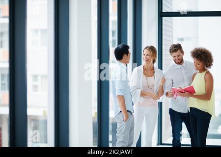 Una buona comunicazione è il cuore di un grande team. Foto di un gruppo di colleghi che hanno una conversazione in ufficio. Foto Stock