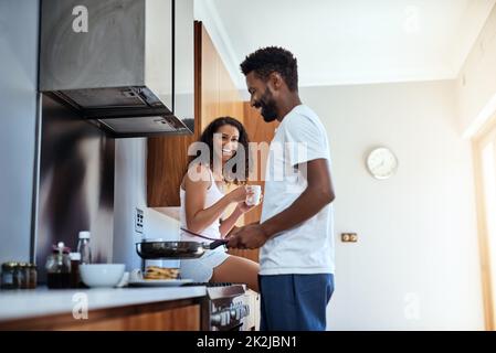 Ama guardarlo cuoco. Scatto corto di un bel giovane che cucinava in cucina mentre sua moglie guarda sopra. Foto Stock