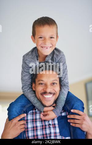 Theres mai un momento noioso quando theyre insieme. Ritratto di un padre che porta il figlio sulle spalle a casa. Foto Stock