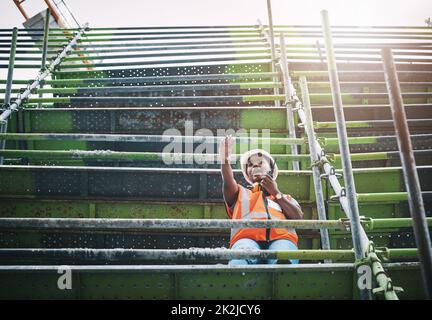 Pianificazione, organizzazione e direzione del completamento di un nuovo sito. Scatto di una giovane donna utilizzando un walkie talkie mentre si lavora in un cantiere. Foto Stock