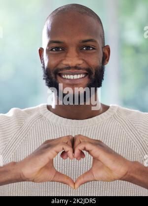 Ti cuore. Colpo di un giovane che fa un cuore forma con le sue mani. Foto Stock