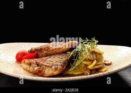 Pezzi di pesce fritto con patate fritte con funghi, pomodori ed erbe aromatiche Foto Stock