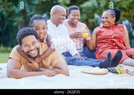 Famiglia nera, pic-nic e padre legame con la ragazza nel parco naturale e giardino pubblico. Ritratto di sorriso, uomo felice o divertente con bambino piccolo, nonni Foto Stock