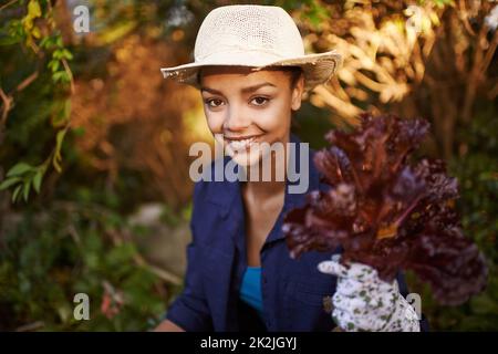 Il giardinaggio è il tipo migliore di terapia. Shot di una giovane donna giardinaggio nel suo cortile. Foto Stock
