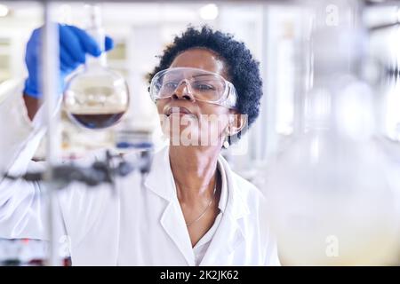 Questa potrebbe essere la prossima scoperta rivoluzionaria. Shot di una scienziata femminile che lavora in un laboratorio. Foto Stock