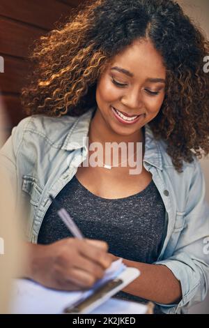 È stato veloce e conveniente. Scatto di una giovane donna che firma per la sua consegna dal corriere. Foto Stock