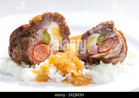 involtini di manzo ripieni di uova, salsiccia, pancetta e pollo serviti con riso Foto Stock