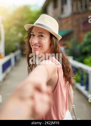 Andiamo a esplorare. Ritratto di una giovane donna in vacanza che conduce il suo ragazzo inidentificabile per mano. Foto Stock