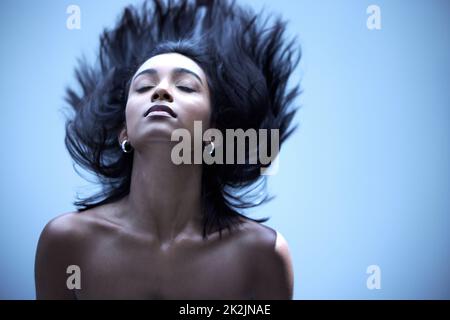 I miei capelli non sono mai stati più silkier. Scatto di una giovane donna con capelli meravigliosi in uno studio. Foto Stock