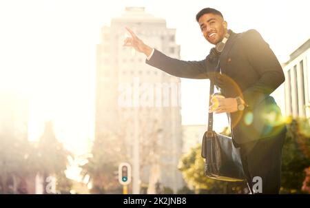 Una cabina per una. Shot di un bel giovane uomo d'affari che si accanita un taxi. Foto Stock