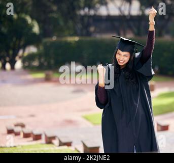 Ottenete soltanto che cosa lavorate per. Scatto corto di una giovane studentessa attraente che festeggia il giorno della laurea. Foto Stock