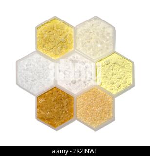 Ingrediente chimico in contenitore esagonale di forma molecolare. Scaglie di solfuro di sodio, cera microcristallina, polietilene, esteri cetilico cera, polvere di zolfo, Cera carnauba e cera Candelilla. Foto Stock