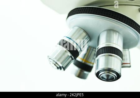 Lente obiettivo di microscopio isolata su sfondo bianco Foto Stock