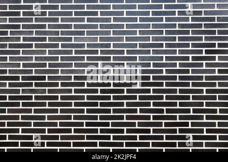 Moderno muro esterno in mattoni neri, sfondo, texture con boiacca bianca Foto Stock